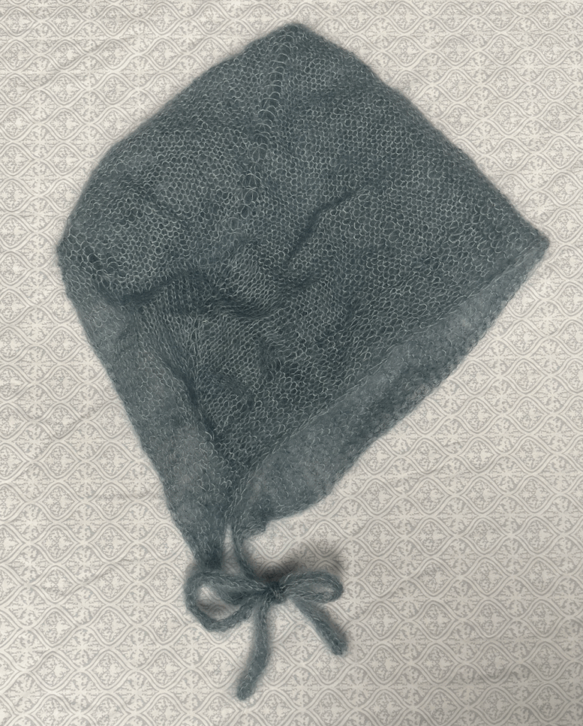 Blue knit bonnet on neutral background